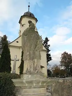 Socha sv. Jana Nepomuckého, za ní kostel sv. Markéty