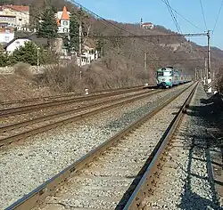 Pohled na kostel z železničního přejezdu ve Velké Chuchli