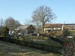 Stavení s dřevěným plotem, u stromu
