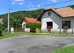 tři domy u cesty, v pozadí les