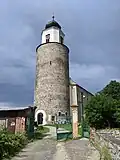 Žulová (dř. Frýdberk, Friedeberg) - kostel sv. Josefa s pozůstatkem hradu Frýdberka.jpg