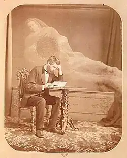 Bugueho Antispirituální fotografie. Přízrak drží v ruce tabulku s nápisem: Raději Mesmer a Cagliostro. Duchové, ze kterých si můžete vybrat. Úspěch je zaručen. Neviditelná manipulace pod nosem klienta. Triky spiritualistů.
