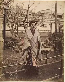 Japonská žena v tradičním kroji pózuje venku, 1870–1880