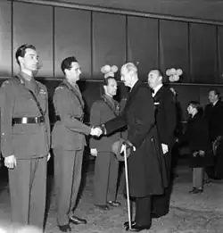 Král Haakon VII. podává ruku Poulssonovi a dalším odbojářům na slavnostní norské premiéře filmu Boj o těžkou vodu (1948)