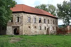 Pohled na bránu a západní křídlo z návsi. Vlevo torzo novodobé přístavby lihovaru
