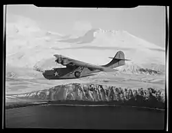 Bombardér PBY-5A Catalina při vyhledávání nepřátelské činnosti. Na pozadí jsou zasněžené hory na ostrovech Aleutian Islands, březen 1943.