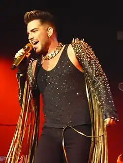 Adam Lambert s hudební skupinou Queen během Queen + Adam Lambert Tour 2014–2015