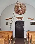 Pohled na západní stěnu s malbou archanděla Michaela a historickými nápisy