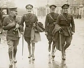 skupina čtyř mužů v uniformách kráčejících po ulici