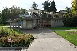 Sjednocená hřinová střecha v kolonádě z pohledového betonu. Allenmoos, Curych