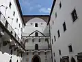 Nádvoří vzniklo po odbourání klenby lodi původního farního kostela.