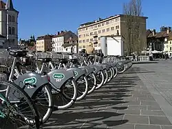Řada zaparkovaných jízdních kol, všechna stejného typu