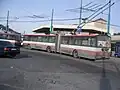 Konečná trolejbusů a autobusů MHD před stanicí, v pozadí „Skleník“