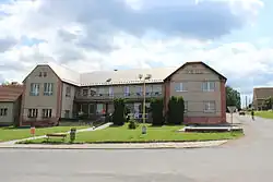 Patrový podlouhlý objekt se šikmou střechou. Dům je na obou koncích (vlevo i vpravo) zakončen rizality.