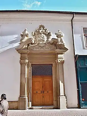 Vstup do kláštera minoritů z Minoritské ulice v Brně. Nad vstupem je znak minoritů, zkřížené ruce
