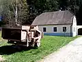Mlátička "Ježek", v pozadí usedlost