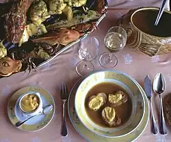 Bouillabaisse v tradiční úpravě s opečenými plátky chleba a přílohami (vlevo omáčka/majonéza rouille, nahoře mořské plody se zeleninou)