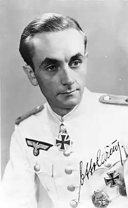 Otto Carius jako nadporučík v bílé slavnostní uniformě. U krku můžeme vidět jeho rytířský kříž s dubovými ratolestmi.
