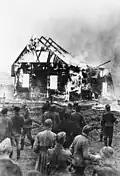 Němečtí vojáci sledují zapálenou synagogu v Litvě, 1941