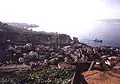 Komíny tepelné elektrárny a sila na cement v Câmara de Lobos. V pozadí Funchal