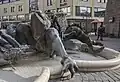 Žena vystupující z mušle, ztělesňující řeckou bohyni Afroditu a symbolizující prvotní okouzlení je obdivována mužem s trumpetou.