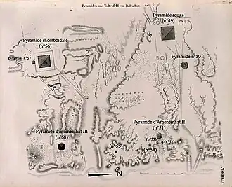Kreslená mapa dáhšurské nekropole. Nahoře v pravém rohu se nachází Červená pyramida s úhlem sklonu 49°. Blízko dole pod ní je zakreslena menší pyramida s úhlem sklonu 50°. V levé horní části mapy je Lomená pyramida s úhlem sklonu 56°. V její těsné blízkosti nalevo se nachází drobná pyramida s úhlem sklonu 57°. Dole pod ní v levém dolním rohu je umístěna pyramida Amenemheta III. s úhlem sklonu 58°. V pravé dolní části mapy se nachází pyramida Amenemheta II. s úhlem sklonu 51° a kolem ní jsou rozmístěny čtyři drobné pyramidy s úhly sklonu 52°, 53°, 54° a 55°.