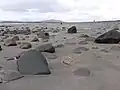 Typická pláž s jemným pískem a velkými balvany