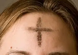 Popelec, křížek z popela, na čele.