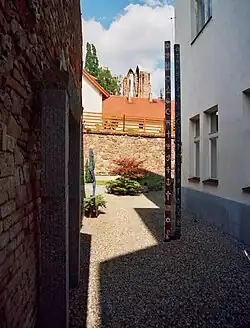 Prostor dvora zrekonstruovaný koncem 90. let pro muzejní expozici české plastiky. Uprostřed symbolický objekt Twin towers, v pozadí ruina minoritského kláštera.