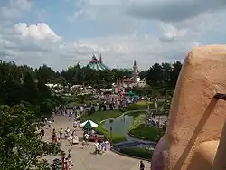 Chodník kolem jezírka oddělený zábradlím.
