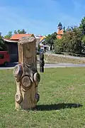 Dřevěné sochy u Kapetovy ulice, v pozadí kostel svatého Vavřince
