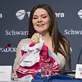 Dina Garipova na tiskové konferenci s jejím maskotem panenkou bábuškou