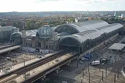 Barevná fotografie s pohledem shora na rozlehlý komplex nádražních budov kolem trati