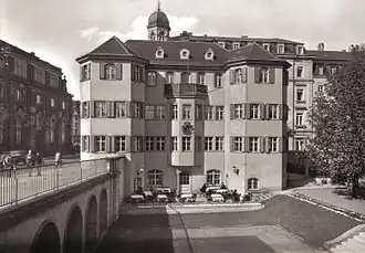 Černobílá fotografie zachycující barokní dům s věžičkou