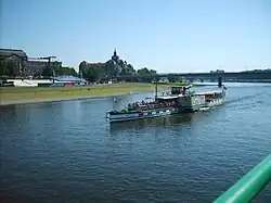 Barevná fotografie s pohledem na výletní loď uprostřed klidné hladiny Labe
