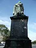 Jeho socha v Remeši zezadu