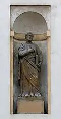 Socha svatého Pavla umístěná v nice na fasádě kostela (nalevo od Panny Marie).