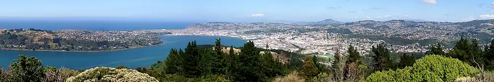 Pohled z vrcholu Signal Hill; Dunedin je ve středu obrázku; poloostrov Otago Peninsula vybíhá doleva