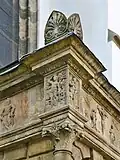 Detail nároží s postavami (zleva) sv. Pavla, sv. Šebestiána, sv. Jana Evangelisty a výjevem Ukřižování
