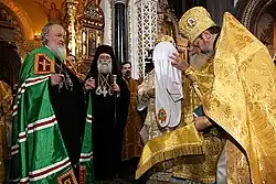 Pravoslavný patriarcha Kyrill v zelené mantii slovanského stylu