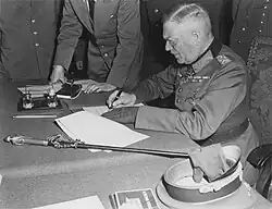 „Polní maršál Keitel při podepisování kapitulaci nacistického Německa v Berlíně dne 8. května 1945.“