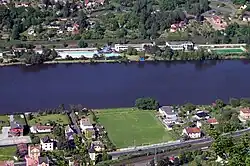 Dvě sídla oddělená řekou. Na jednom břehu s fotbalovým hřištěm, na druhém s koupalištěm.