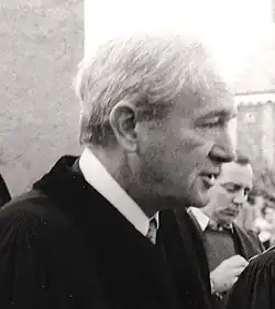 Režisér filmu Planeta opic Franklin J. Schaffner je zachycen z profilu na černobílé fotografii, jak mluví s lidmi