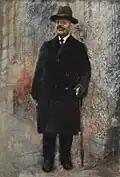 Portrét stojícího muže v černém kabátě a klobouku