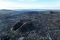 Ztuhlé lávové pole a spečený kužel s Grindavíkem v pozadí, 46 dní po konci erupce (6. srpen)