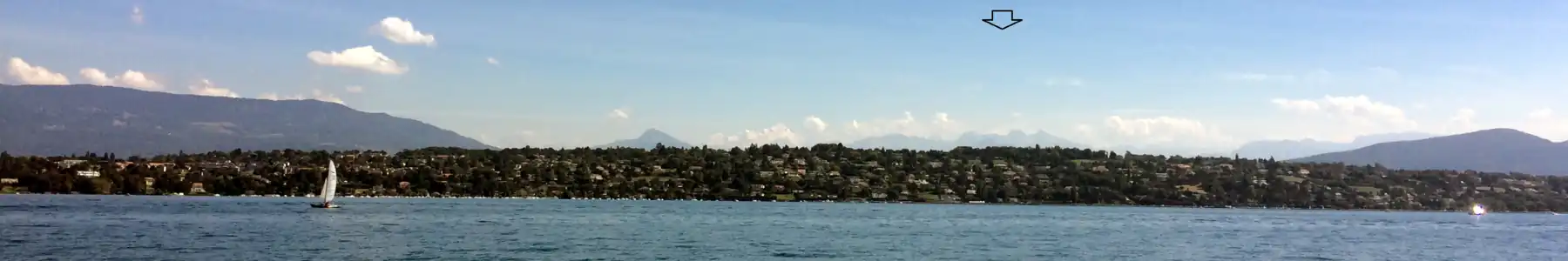 Jižní břeh v Cologny u Ženevy, pohled na jihovýchod. V pozadí masiv Mont Blanc (pod šipkou).
