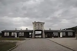 Hlavní brána koncentračního tábora Gross-Rosen s nápisem Arbeit macht frei