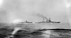 Britské bitevní lodě HMS Warspite a HMS Malaya plující na horizontu během bitvy u Jutska.