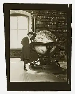 Helen Johns Kirtland leaning on a globe