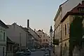 Pražská ulice, rok 2017, v okolí bývalého obchodu Franze Dlouhého je patrný důsledek negativního vývoje po roce 1945, zjednodušení fasád a vzniklá proluka